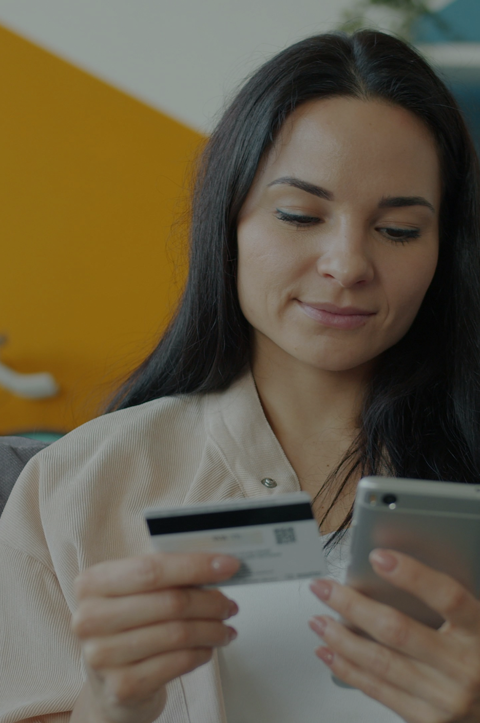 Kobieta dokonująca płatności online za pomocą telefonu i karty – ilustracja funkcjonalności sklepu internetowego